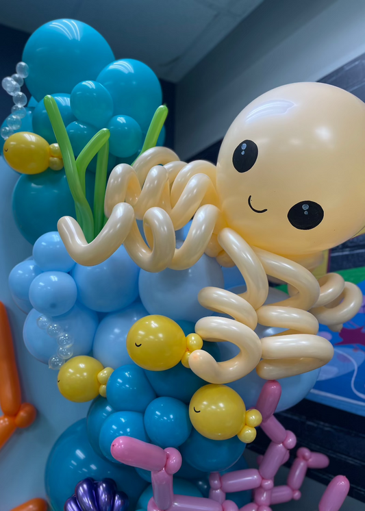 Close-up of a balloon octopus with curly tentacles surrounded by balloon fish, sea bubbles, and ocean greenery. This design is part of the Under the Sea Balloon Class, ideal for under the sea-themed parties, aquatic baby showers, or ocean-inspired event decor.