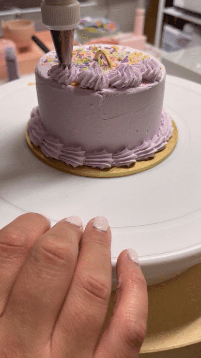 A lavender balloon cake weight is being decorated with piped details using faux frosting, creating a realistic and whimsical design. Sprinkles and a gold handle complete the look, making this sweet treat-inspired balloon weight perfect for stylish setups. Lilly Jimenez teaches this fun and budget-friendly project in her Balloon Weights Class—just don’t take a bite!