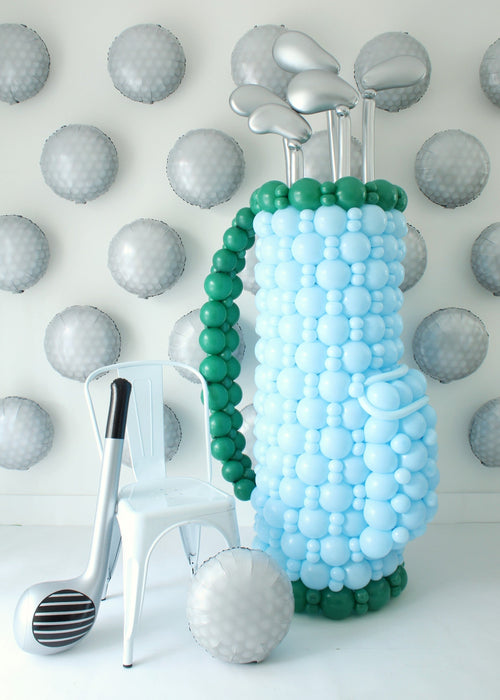 Golf Balloon Class display featuring a large balloon golf bag with clubs, a balloon golf ball, and a giant balloon golf club. This oversized balloon structure is included in the 2 video lessons and makes stunning décor for golf tournaments, birthdays, retirements, corporate events, Father’s Day, and sports-themed store openings. Perfect balloon golf décor idea that’s easy to customize with logos for branded events.