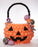 An oversized balloon pumpkin treat bucket made from orange balloons with a black jack-o-lantern face, twisted black balloon handle, and colorful balloon candies attached. This creative Halloween balloon design is perfect for festive displays, parties, school events, and seasonal photo backdrops.