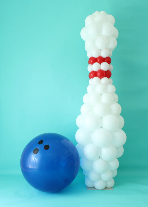 Bowling Pin Column Balloon Recipe featuring a tall 6.5ft white balloon pin with red accent bands, displayed alongside a large blue balloon bowling ball on a teal backdrop. This digital recipe includes a PDF with balloon sizes, step-by-step instructions, a shopping list, and a PNG mockup file. Perfect for creating professional sports-themed balloon decor for school events, tournaments, parties, and celebrations.