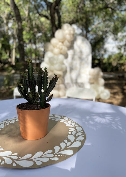 Terracotta potted cactus centerpiece placed on a kraft paper table overlay with a white papel picado-inspired design. The matching balloon and foam board backdrop is visible in the background, creating a cohesive fiesta-themed setup perfect for weddings, showers, or cultural celebrations. Ideal for use with SVG or DXF cut files for CNC or laser cutting machines.