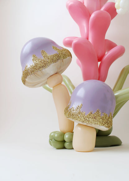 Close-up of purple balloon mushrooms with gold glitter edges, part of Lilly Jimenez’s enchanted decor.