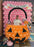 A person poses inside a large balloon pumpkin bucket photo op featuring an oversized jack-o-lantern made of orange balloons with black face details, decorated with balloon candy props and a twisted black handle. The setup includes a pink balloon backdrop with a “Trick or Treat” banner, creating a festive Halloween balloon display for parties, schools, and seasonal events.