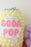 K-pop Demon Hunters themed soda pop balloon prop made with yellow balloons and topped with silver balloon details, featuring a large pink and white “My Little Soda Pop” label, perfect for themed parties, photo ops, and pastel K-pop inspired decor setups.