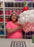 Lilly smiles while holding an oversized balloon cupcake featuring pink and white frosting details, topped with a red balloon cherry and green stem. This playful and whimsical design is part of her Linking Balloon Cupcake Tutorial, perfect for birthdays, candy-themed parties, and balloon decorators looking for fun statement pieces.