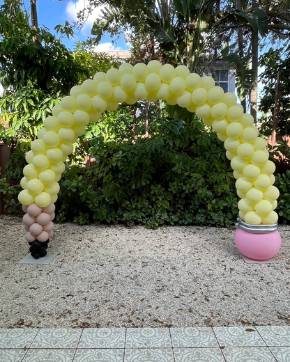 Yellow pencil balloon arch with a pink eraser base and black pencil tip balloons, set outdoors in front of lush greenery. Perfect for back-to-school parties, teacher appreciation events, or classroom décor. This design is featured in the Pencil Balloon Arch Tutorial.