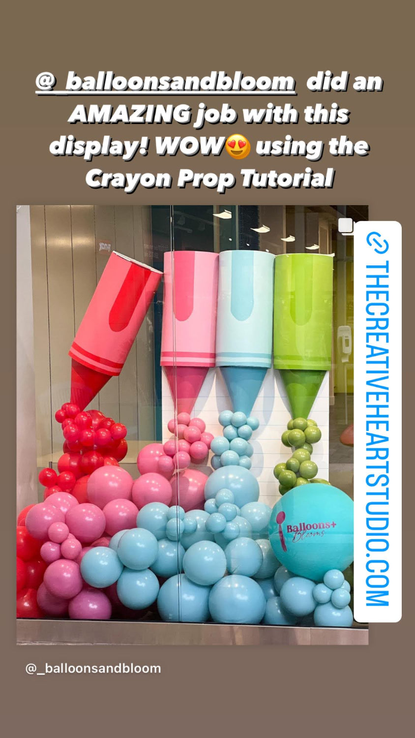 Storefront balloon display created by @_balloonsandbloom using the Crayon Prop Tutorial by Lilly Jimenez. Features oversized red, pink, blue, and green crayon props with matching balloon garlands for a colorful, eye-catching installation. A branded balloon with “Balloons and Bloom” adds a professional touch. Great example of student success and real-life use of this playful balloon decor course.