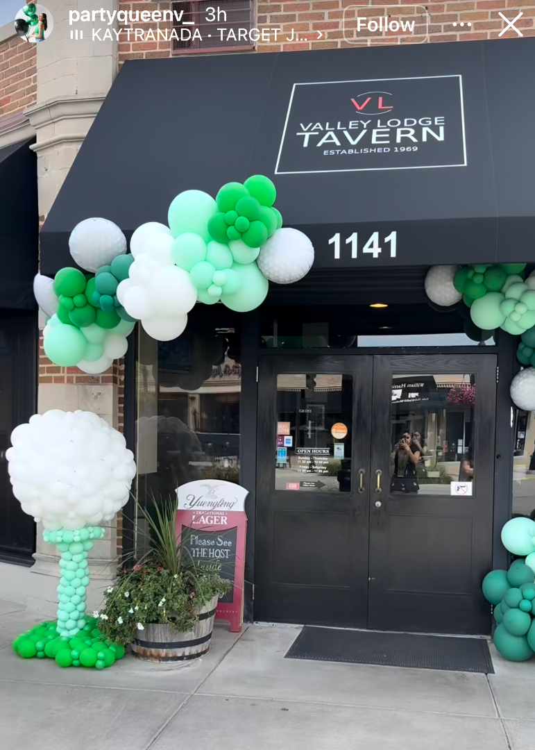 Student made balloon decor featuring a green and white balloon arch and balloon structure installed outside a restaurant storefront. Created by a Creative Heart Studio student, this professional style balloon installation showcases real world event decor skills taught inside balloon classes for storefront openings, holiday events, and brand activations.