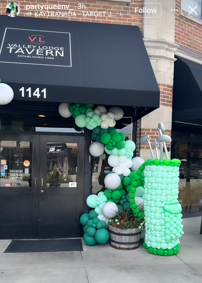 Student made balloon decor featuring a green and white balloon arch and balloon structure installed outside a restaurant storefront. Created by Creative Heart Studio student @partyqueenv_, this real world balloon installation showcases professional event decor skills taught inside balloon classes for storefront openings, brand activations, and holiday events.