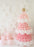 Pink balloon Christmas tree built with layered pink and white balloons and topped with a gold star. White balloon snowflakes decorate the wall behind it with pastel balloons gathered at the base. This holiday backdrop is the same design you can learn step by step inside the Whimsical Balloon Christmas Tree Class, perfect for balloon artists and Christmas installs.