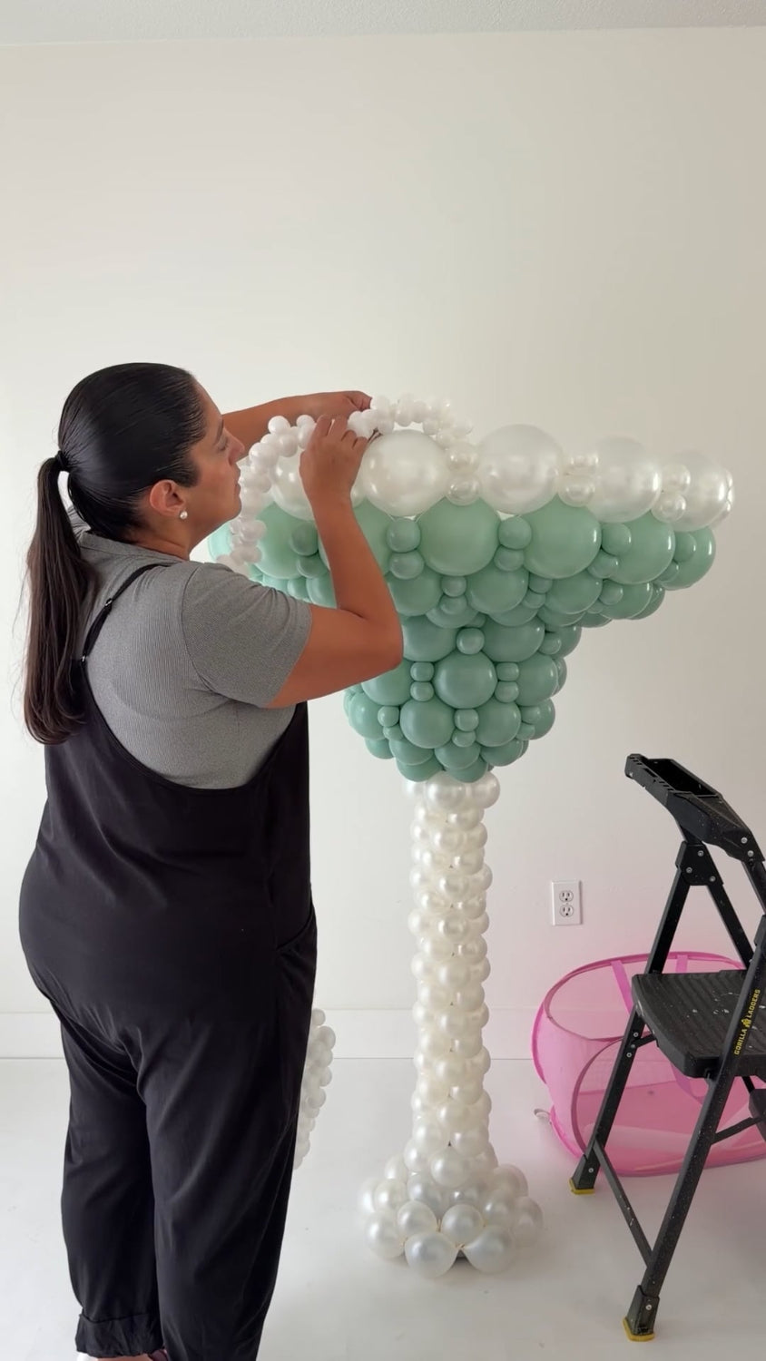 Lilly Jimenez attaching the white balloon salt rim to an oversized Margarita Glass Balloon Sculpture