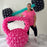 Lilly Jimenez standing next to oversized pink balloon kettlebell with black and teal balloon barbell sculpture, fitness themed balloon decor for gym events, health brand activations, and workout inspired party setups.