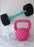 Oversized pink balloon kettlebell and black balloon barbell with teal handle next to white chair, fitness themed balloon decor for gym events, workout parties, and health brand activations.
