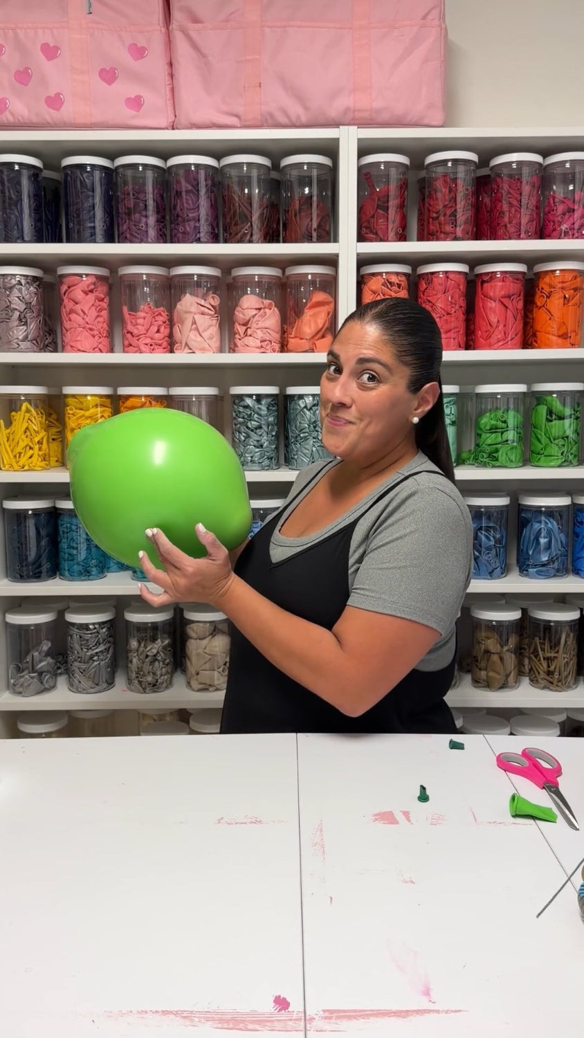 Lilly Jimenez holding a large green balloon lime during the Margarita Glass Balloon Sculpture tutorial