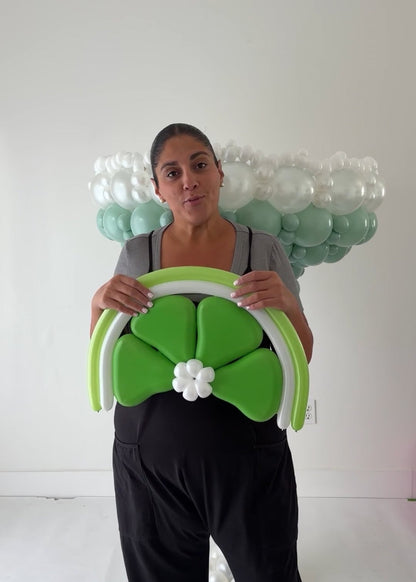 Lilly Jimenez holding a large balloon lime wedge in front of the Margarita Glass Balloon Sculpture
