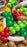 Close up of balloon taco showing lettuce, tomato, and filling details being placed by hand