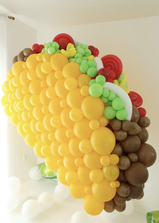 Side view of large balloon taco sculpture showing shell and layered filling details