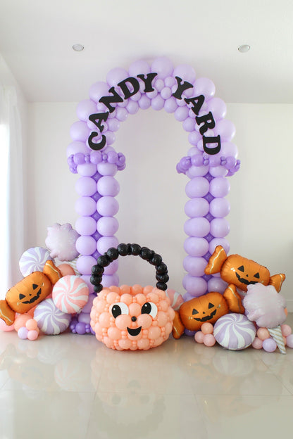 Candy Yard Halloween balloon arch with tuxedo-style columns, decorative balloon trim, and Candy Yard lettering.