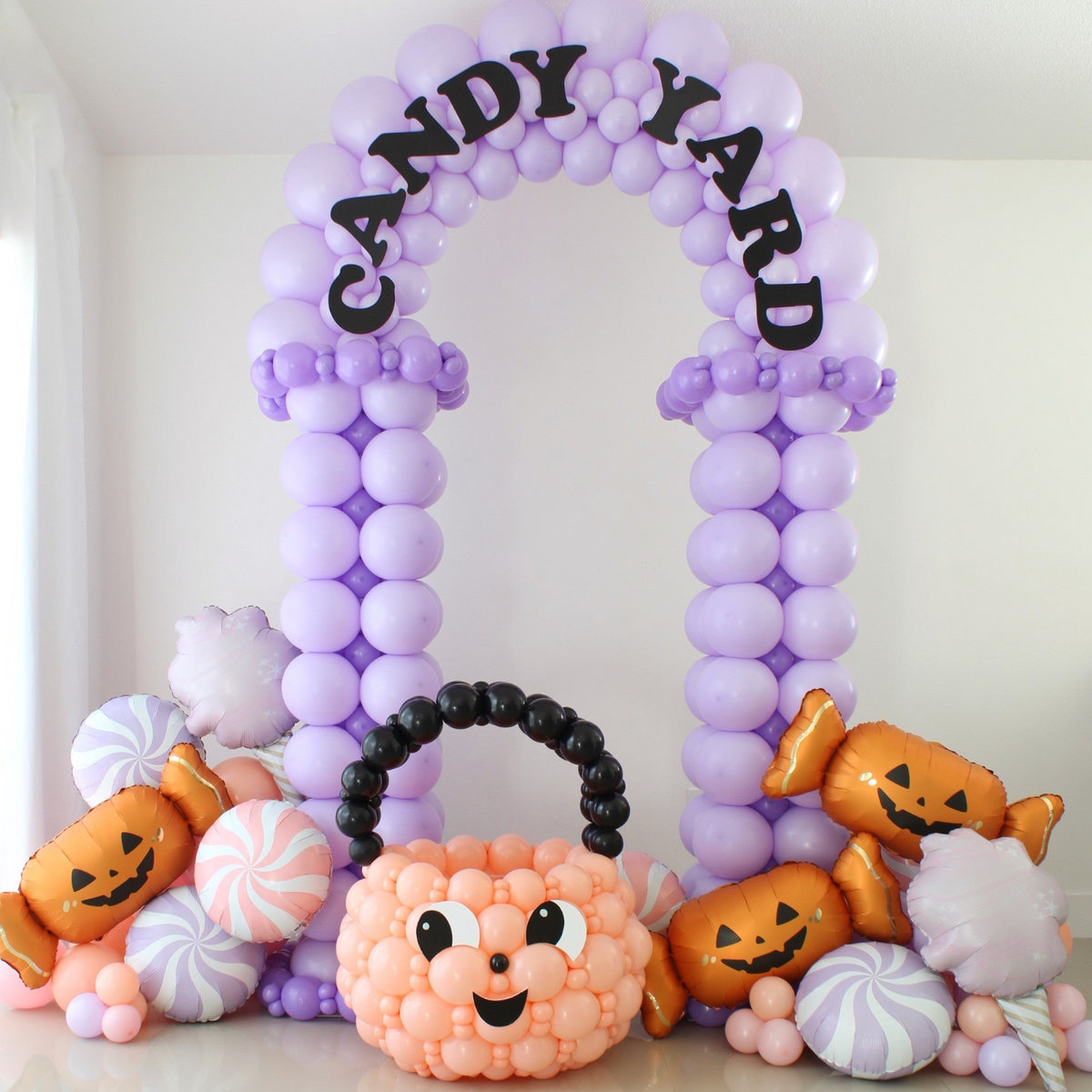 Candy Yard Halloween balloon arch with tuxedo-style columns, decorative balloon trim, and Candy Yard lettering.