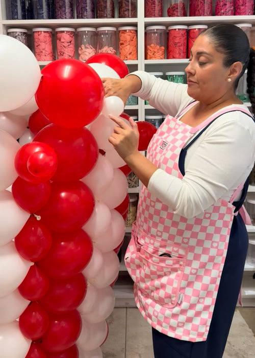 Lilly assembling red and white striped balloons for the giant balloon popcorn bucket in the Cinema Party Decor Class, teaching movie night balloon decorations, Hollywood themed party props, and DIY cinema event decor.
