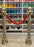 Gold balloon stanchions with a red balloon rope for red carpet entrances, cinema party decor, Hollywood themed birthdays, movie night events, award show parties, and VIP photo op displays.