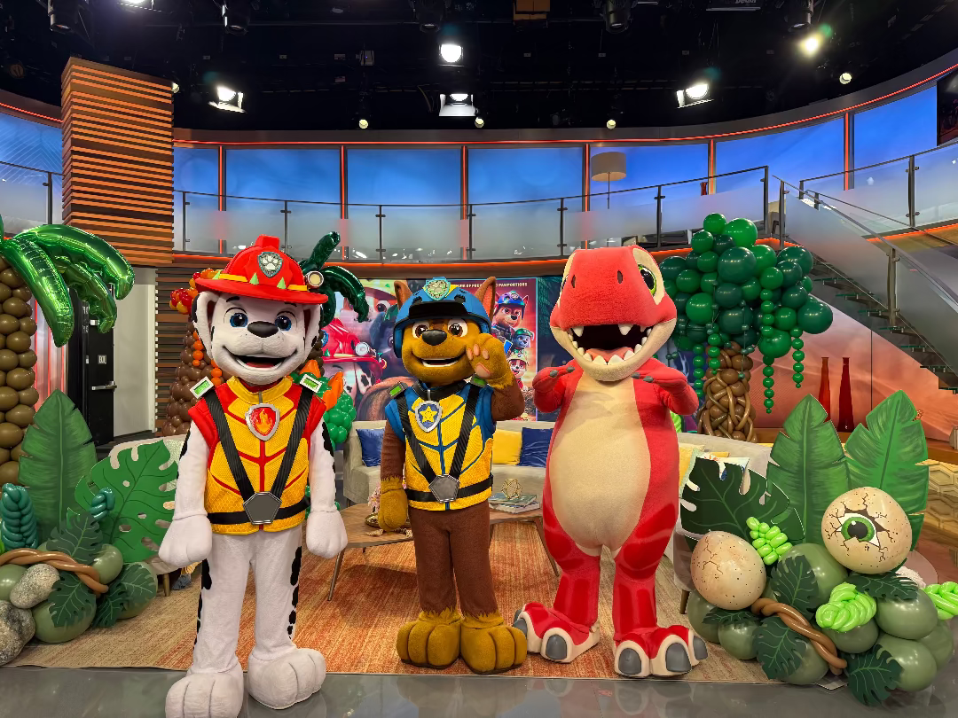 PAW Patrol movie promotion with costumed characters and dinosaur-themed balloon decor on Despierta América on Univision.