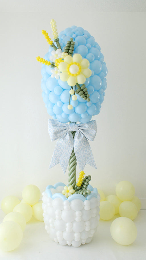 side view of Easter egg balloon column topiary with basket base, balloon flowers, and bow for spring event decor