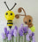 Giant balloon bee and glowing light bug sculpture created by Lilly Jimenez, displayed among purple balloon flowers. Oversized spring balloon decor featuring a yellow and black bee and whimsical light bug, perfect for garden theme parties, birthday backdrops, baby showers and professional balloon installations.
