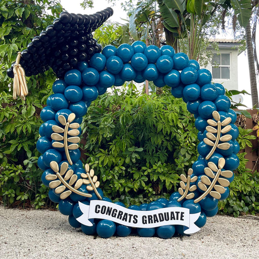 Lilly Jimenez graduation balloon arch with oversized balloon cap, gold balloon flowers, and congrats graduate banner for graduation balloon decor and photo backdrop