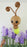 Giant light bug balloon character with spiral antennae and soft yellow body hovering above layered purple balloon flowers. Spring balloon decor design for garden themed parties, baby showers and professional balloon event styling.