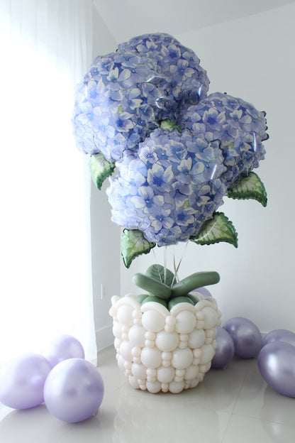 Linking balloon flower pot with oversized blue hydrangea foil balloons, green balloon leaves, and a textured white balloon pot.