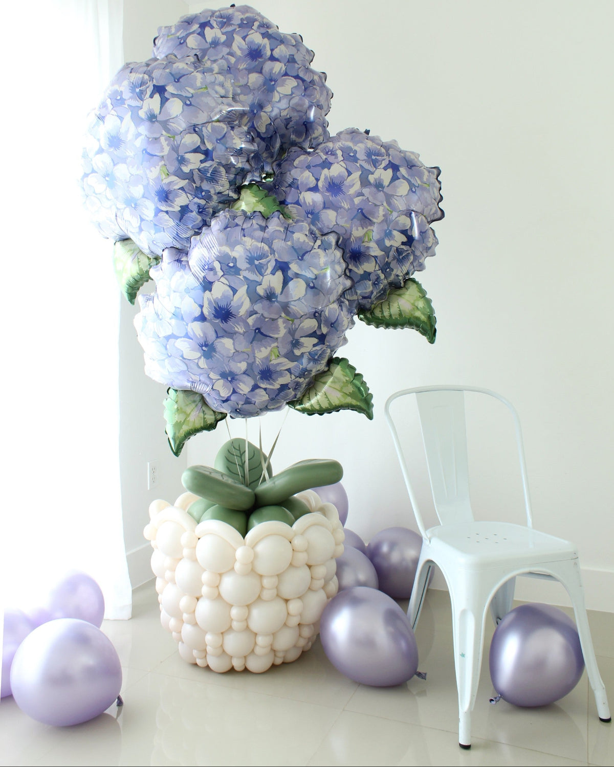 Oversized blue hydrangea foil balloons arranged in a white linking balloon flower pot with green balloon leaves.