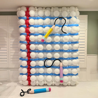 Notebook paper balloon wall by guest instructor Victoria Dzierza with blue lines, a red margin, and oversized balloon pencils.