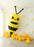 Large scale balloon bumble bee installation featuring clustered yellow and black balloons with extended antennae. Spring themed balloon decor staged with yellow balloons and wall florals, ideal for garden parties, kids birthdays and statement event backdrops.