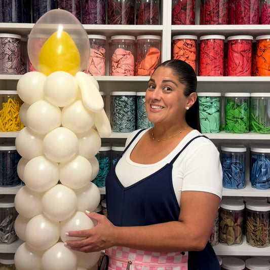 Oversized white balloon candle with yellow flame created by The Creative Heart Studio for a balloon decor tutorial.