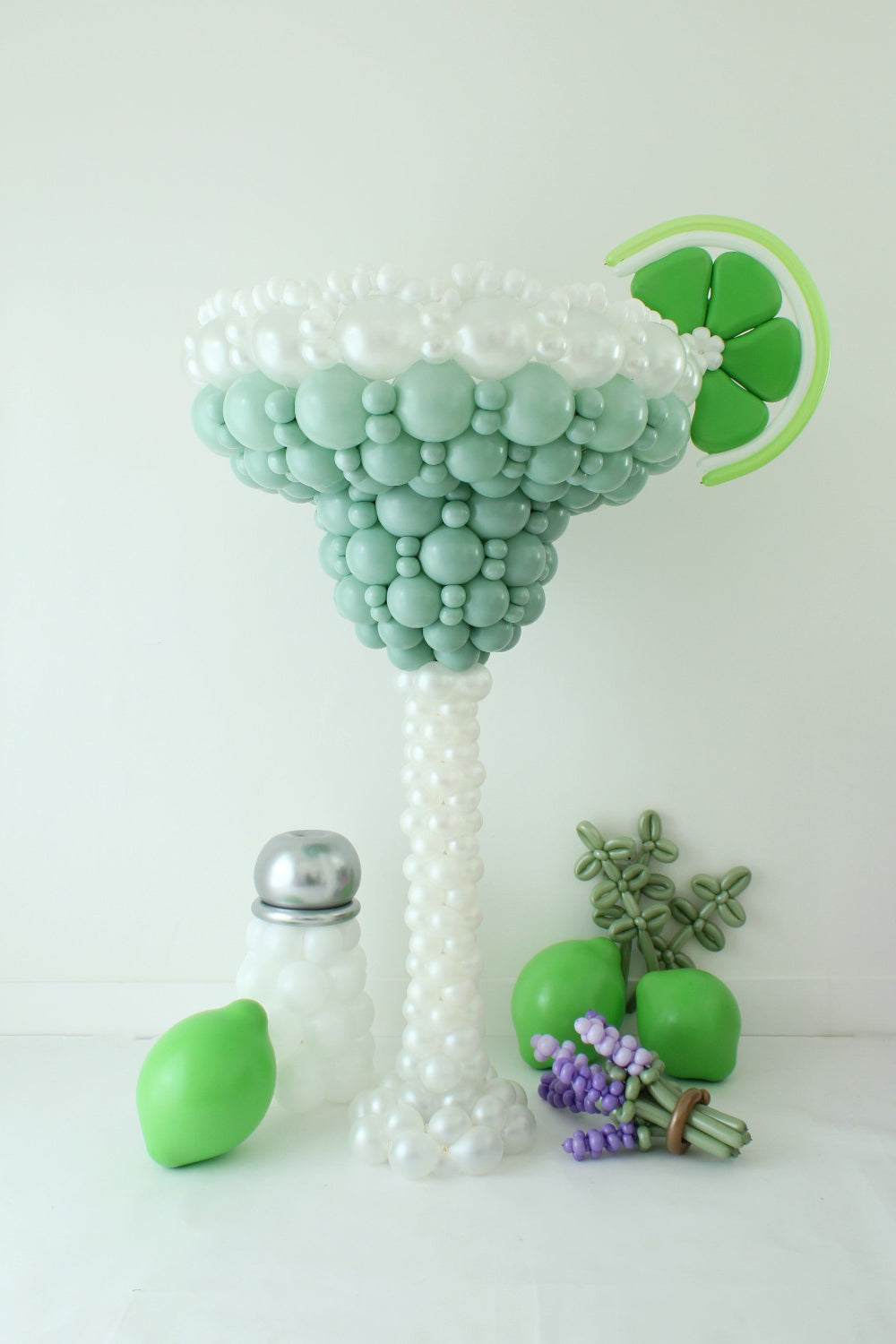 Five-foot Margarita Glass Balloon Sculpture with a balloon salt rim, lime wedge, salt shaker, limes, and lavender accents
