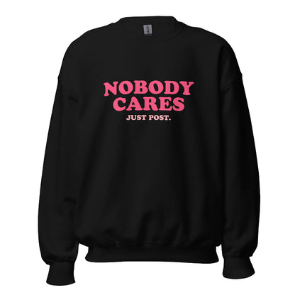 Black sweater featuring the phrase "Nobody Cares, Just Post" in bold pink and white lettering, perfect for content creators and casual wear.