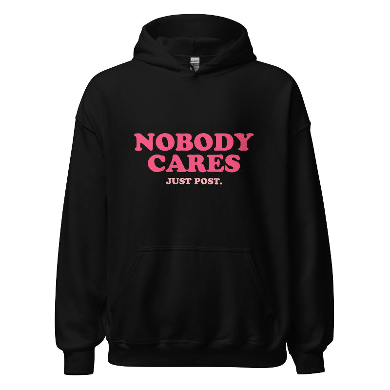 Black hoodie featuring the phrase "Nobody Cares, Just Post" in bold pink and white lettering, perfect for content creators and casual wear.