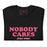 folded black t-shirt featuring the phrase "Nobody Cares, Just Post" in bold pink and white lettering, perfect for content creators and casual wear.