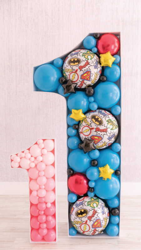 Balloon mosaic number ones in pink and superhero-themed blue, designed using techniques from the Balloon Mosaic® 101 Course. Created by Lilly Jimenez—the original inventor of the Balloon Mosaic®—this display showcases her signature approach to cutting, building, and filling mosaics for impactful, photo-ready event decor.