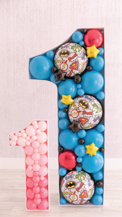 Balloon mosaic number ones in pink and superhero-themed blue, designed using techniques from the Balloon Mosaic® 101 Course. Created by Lilly Jimenez—the original inventor of the Balloon Mosaic®—this display showcases her signature approach to cutting, building, and filling mosaics for impactful, photo-ready event decor.